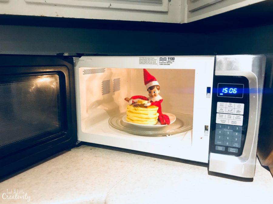 Elf on the shelf hiding in the microwave eating pancakes