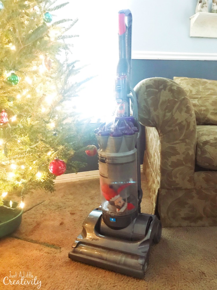 Elf on the shelf hiding in the vacuum canister