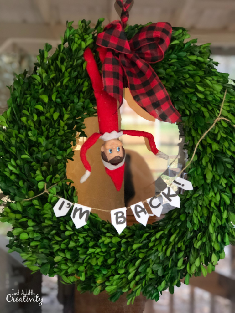 Easy Elf on the Shelf Returns Idea. Hanging in a door wreath with an I'm Back bunting.